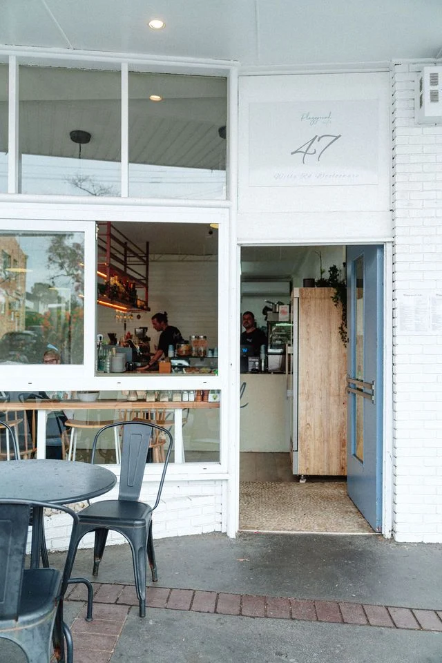 A restaurant with a table and chairs outside of it.