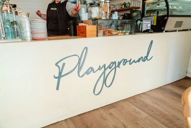 The Playground Cafe counter with its hand-painted script wordmark