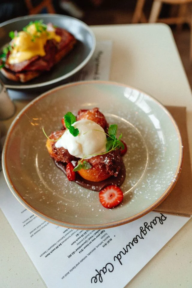A plate of food with ice cream and strawberries on a table.
