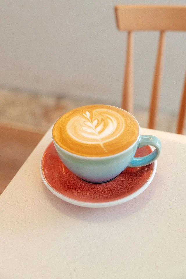 Coffee with latte art on a colourful saucer