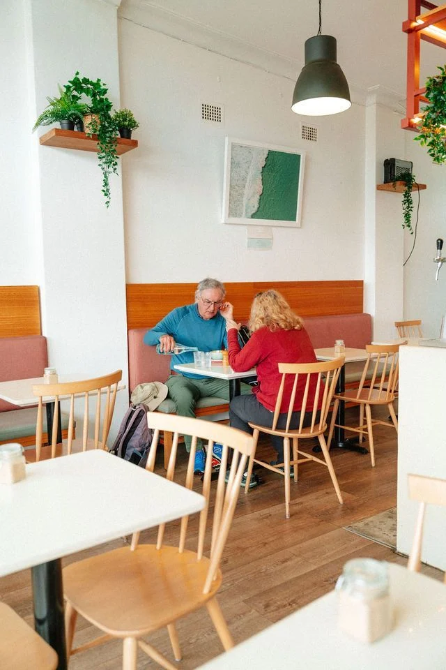 A man and a woman are sitting at a table in a restaurant.