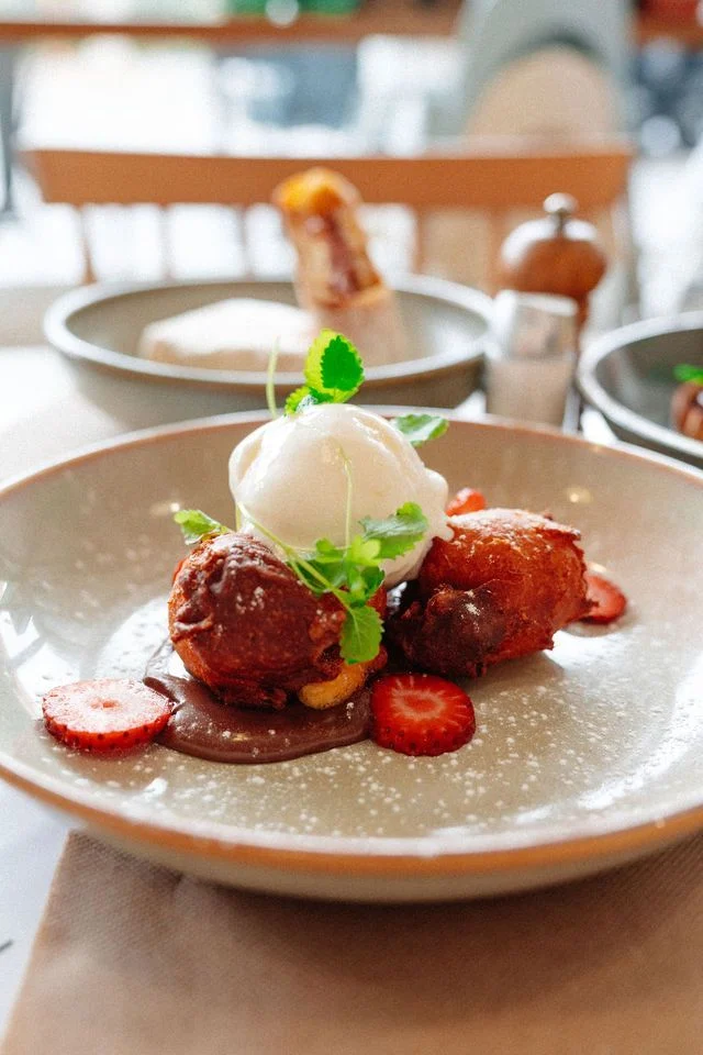 A plate of food with ice cream and strawberries on a table.