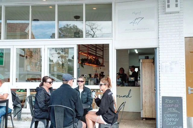 A group of people are sitting outside of a restaurant.