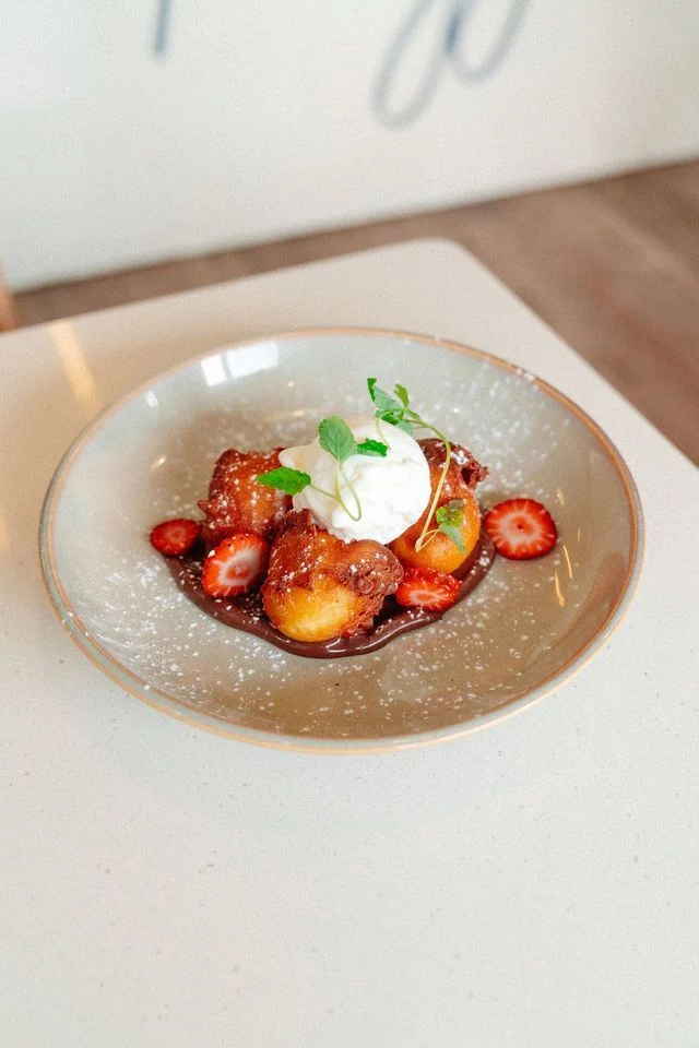 A plate of food with strawberries and ice cream on a table.